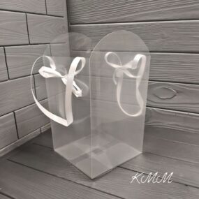 Сумка - переноска прозрачная с лентами Прозрачная Материал ПВХ С ручками - лентами Размеры: Размеры по дну 16 см х 16 см Высота 29см - высокая часть, 24см - низкая часть Подойдет для любых цветочных композиций из мыла. Сумка станет прекрасным дополнением для вашего мыльного букета. Композиция будет выглядеть изысканно и стильно. Настройки экрана вашего устройства могут искажать цвет изделия.