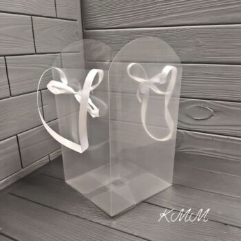 Сумка - переноска прозрачная с лентами Прозрачная Материал ПВХ С ручками - лентами Размеры: Размеры по дну 16 см х 16 см Высота 29см - высокая часть, 24см - низкая часть Подойдет для любых цветочных композиций из мыла. Сумка станет прекрасным дополнением для вашего мыльного букета. Композиция будет выглядеть изысканно и стильно. Настройки экрана вашего устройства могут искажать цвет изделия.